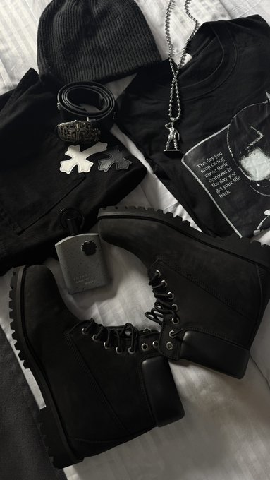 A black outfit is laid out, including a beanie, t-shirt with text that reads, "The day you stop caring about their opinions is the day you get your life back," belt, boots, and a pendant necklace. This image likely shows the outfit chosen for meeting someone, as indicated by the accompanying post.