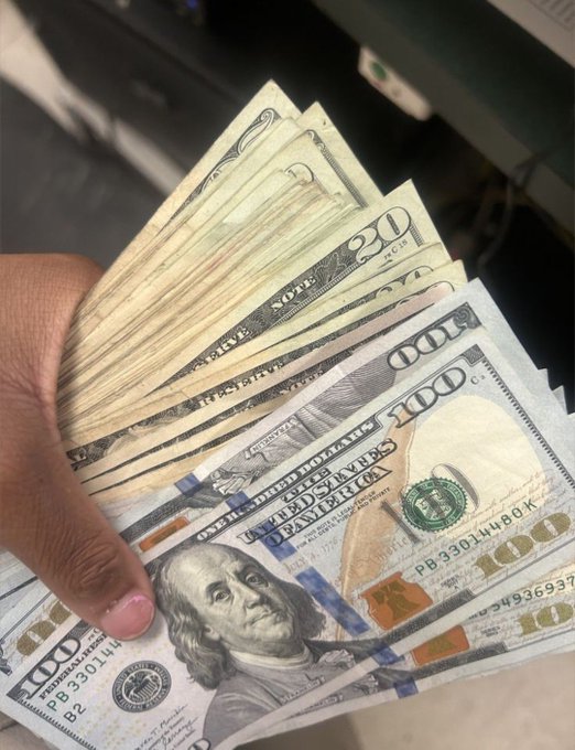 A hand fans out a stack of U.S. currency, prominently featuring $100 bills with Benjamin Franklin's portrait and a few $20 bills, symbolizing the earnings and financial success being celebrated in the post.