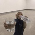 A small GIF of a man in a suit holding up a glass of water, possibly in a bathroom setting.