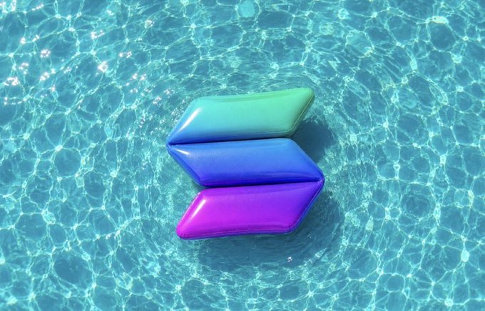 A colorful 3D logo resembling a stylized 'S' in teal, blue, and purple floating above rippling pool water.