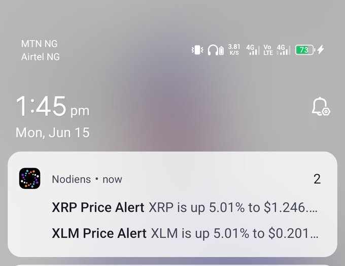 The image shows a smartphone's home screen with various app notifications. On the left side of the display, there are two app icons: one for "Nodien" and another for an exchange app named "XLM". The time displayed on the phone is 1:45 PM on Monday, June 15th. A text message notification can be seen near the bottom right corner of the screen, which reads, "Real Yesterday I traded $XRP and $XLM based on signals from the Nodiens app."
