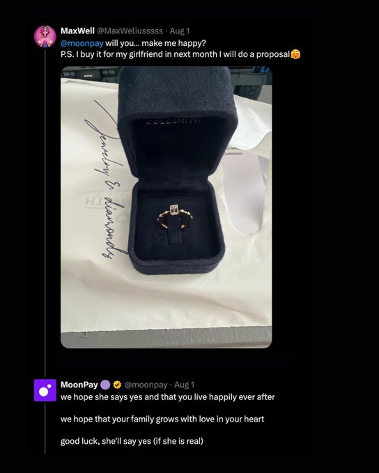 The image shows a tweet exchange between users @MaxWeliusssss and @moonpay, featuring a photo of an engagement ring in a black ring box. The first tweet asks MoonPay to make him happy so he can buy a ring for his girlfriend and propose next month, while MoonPay responds with well wishes, playfully hoping "she'll say yes (if she is real)." The accompanying caption congratulates the user and his bride-to-be, aligning with the celebratory engagement theme depicted in the tweet.