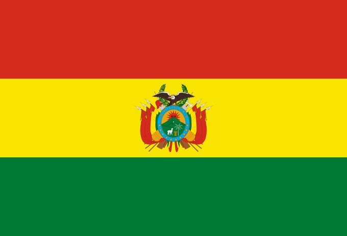 The flag of Bolivia, featuring its distinctive red, yellow, and green horizontal stripes with the national coat of arms at the center, is displayed against the backdrop of the country's potential shift toward integrating USDT (Tether) into its national payments system alongside the US dollar and the boliviano. The image symbolizes Bolivia's evolving stance on cryptocurrency, moving from previous restrictions to exploring stablecoin adoption in its financial infrastructure.