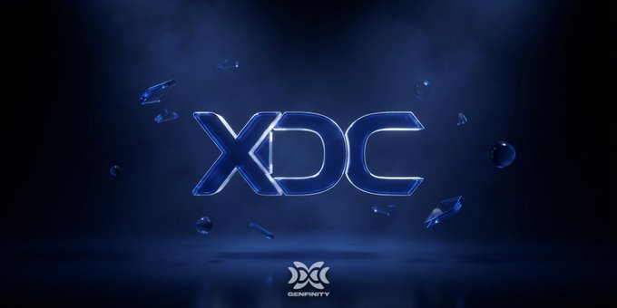 The image displays a logo with the letters "XDC" on a dark blue background, surrounded by small silver balls that appear to be falling from an unseen source. The image also contains text that reads "4 institutional validators in 12 days. $1B tokenized. 71.5% in RWAs. Animoca. Clearpool. BCW. stakeFi. All joined as masternode validators. Cacao trade tokenization went live in production." The post is about a new decentralized currency and its related tokens, which may include XDC and more.