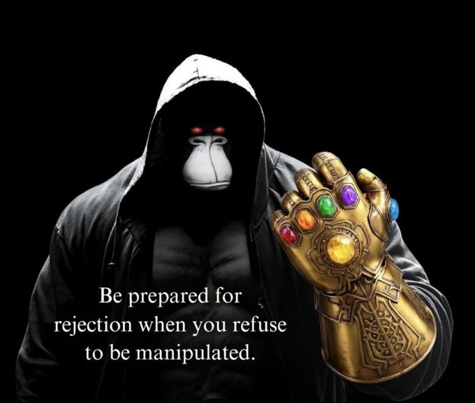 A hooded gorilla with glowing red eyes holds up a golden Infinity Gauntlet against a black background, overlaid with the text: "Be prepared for rejection when you refuse to be manipulated." The image reinforces the post's message of resilience by drawing a parallel to Thanos—a powerful figure who was ultimately rejected despite his manipulative power grab—encouraging $APE holders to study and emulate those who persevere through rejection.