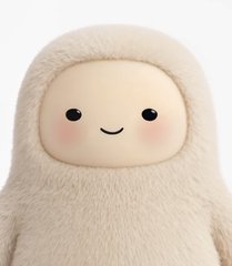 A close-up of a cream-colored plush toy with a simple smiling face, rosy cheeks, and a fuzzy hooded body.