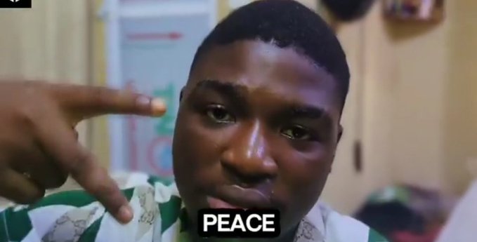 A meme video still showing a close-up of a young Black man looking at the camera and making a peace sign with his hand, with the word 'PEACE' displayed in bold white text at the bottom.