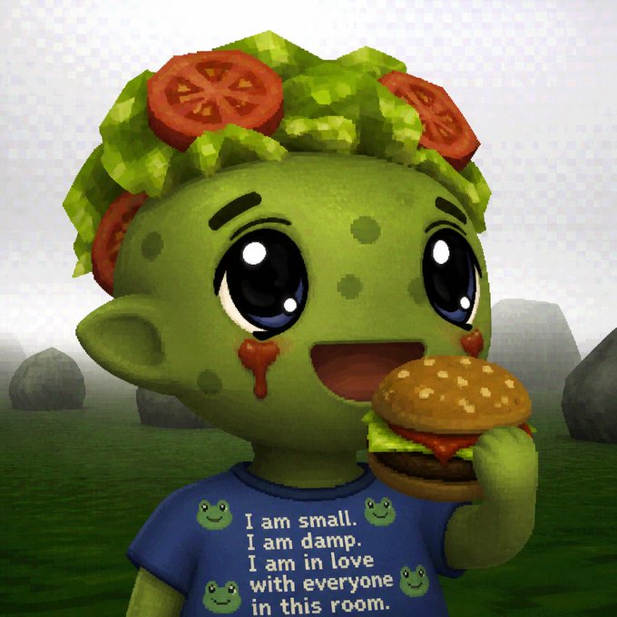 A cute green goblin-like character with a salad-and-tomato hairstyle holds a burger, wearing a blue shirt that reads "I am small. I am damp. I am in love with everyone in this room." The image playfully reinterprets the chaotic meme creature into something charming, humorously fulfilling the post's claim of transforming "kolslop" into cuteness.