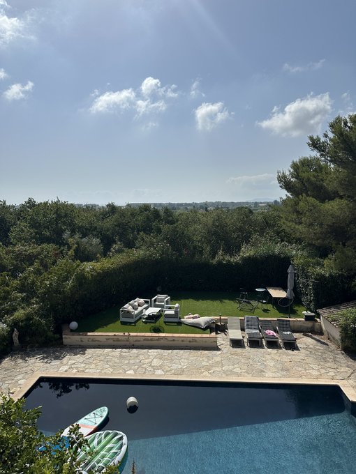 This image shows a luxurious backyard with a swimming pool and lounge area, seemingly representing the lifestyle achieved due to large profits, such as the "$1M REALIZED profits on cashcat" mentioned in the accompanying post.