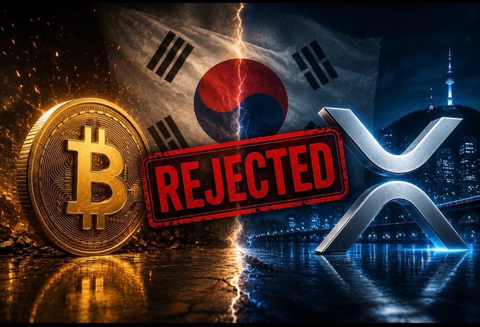 The image features a cracked South Korean flag split down the middle with a bold red "REJECTED" stamp across it, flanked by a golden Bitcoin coin on the left and the glowing XRP logo on the right, visually symbolizing the Bank of Korea's rejection of Bitcoin as a reserve asset and positioning $XRP as the stable alternative.