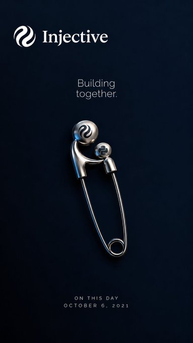 An Injective crypto promotional graphic reads "Building together." and "ON THIS DAY OCTOBER 6, 2021," displaying a metallic safety pin emblem against a dark background.
