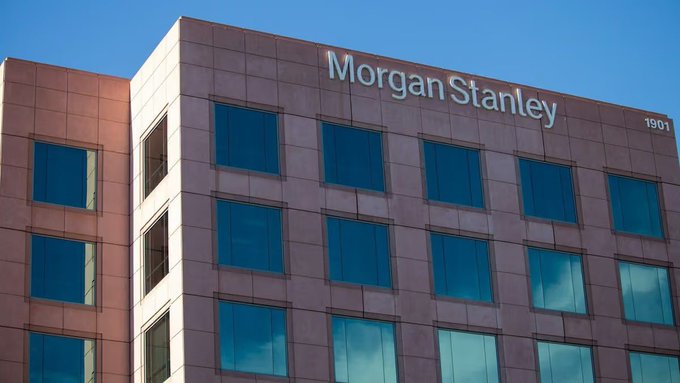 A modern office building with the 'Morgan Stanley' name and '1901' visible on its copper-colored facade with blue-tinted windows.