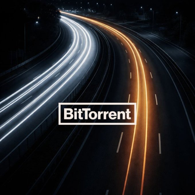 An aerial nighttime view of a highway with light trails from passing cars, overlaid with a 'BitTorrent' logo in a white box.