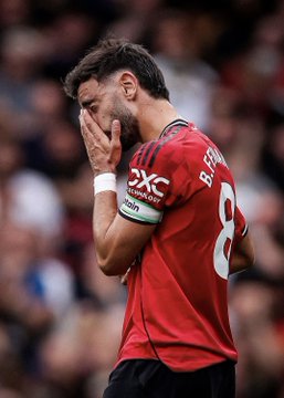 A Manchester United player, wearing jersey number 8, reacts with apparent frustration by covering his face with his hands during a Premier League match. The "DXC Technology" sponsor logo is visible on the sleeve of his red jersey, which is consistent with the context of Manchester City's higher xG (expected goals) than Manchester United despite playing with 10 men since the 23rd minute—suggesting United struggled offensively in the game.