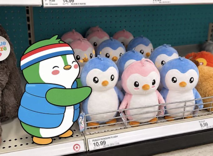 A store shelf displaying pink and blue penguin plush toys ('Pudgy Penguin Plush') priced at $10.99, with a cartoon penguin graphic overlaid on the left side.