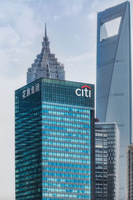 A photograph of the Shanghai skyline featuring a glass skyscraper with "花旗集团" (Citigroup) and the "citi" logo, set against the Jin Mao Tower and Shanghai World Financial Center.