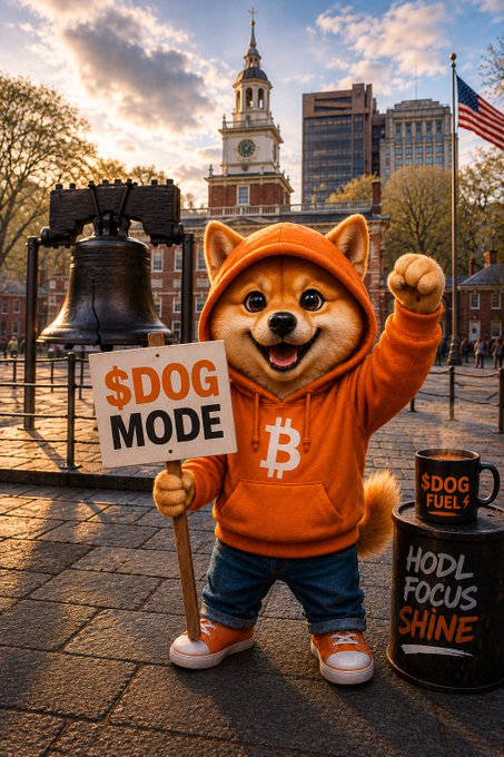 A digital illustration of a Shiba Inu dog wearing an orange hoodie with a Bitcoin logo, holding a '$DOG MODE' sign next to a barrel labeled 'HODL FOCUS SHINE' in front of a city skyline with an American flag.