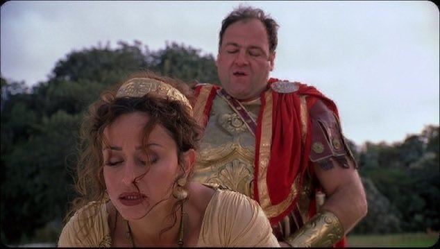 A woman with a golden headpiece and Roman-style jewelry looks weary while a man dressed in ornate Roman armor and a red cape stands behind her in an outdoor setting. The juxtaposition of this dramatic classical scene with the post about Paradex (a crypto trading platform on Starknet) serves as a humorous metaphor for domination or conquest, suggesting Paradex is set to "conquer" its competitors like Hyperliquid in the decentralized exchange space.