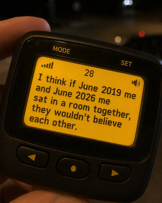 A handheld device with an orange-lit screen displays the message, "I think if June 2019 me and June 2026 me sat in a room together, they wouldn't believe each other," prompting reflection on personal growth in response to the question "How bout yours?"