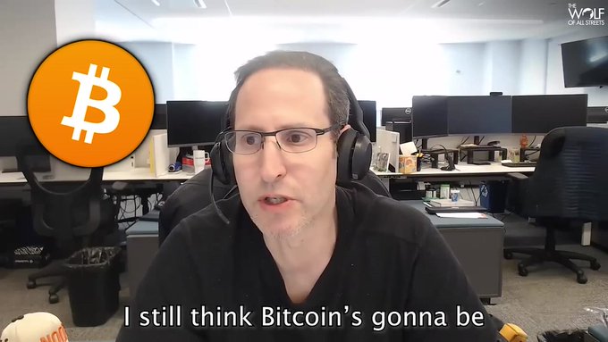 A video still from Wolf of All Streets featuring a man with glasses and a headset in an office setting, with a Bitcoin logo overlay and caption: 'I still think Bitcoin's gonna be'.
