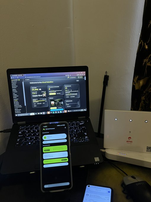 A workspace shows a laptop displaying 'Welcome to the Cloud Rebellion' alongside a smartphone, with an Airtel router on the side.