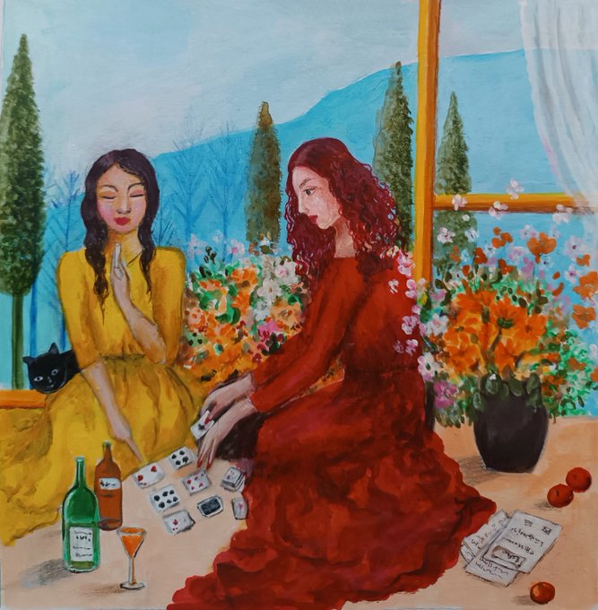 Two women in flowing dresses—one in yellow with braided hair, the other in red with long curls—play cards at a table adorned with wine bottles, fruit, and scattered playing cards, while a black cat sits nearby and a vase of orange flowers blooms against a scenic mountain backdrop.