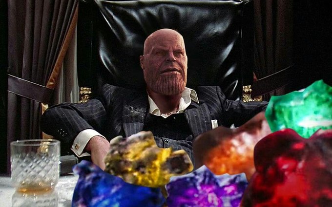 A bald, elderly man in a pinstripe suit sits at a table surrounded by colorful gemstones in purple, green, red, yellow, and orange hues, with a glass of whiskey nearby. The scene visually embodies the post's message about choosing from among many precious options laid out before you.