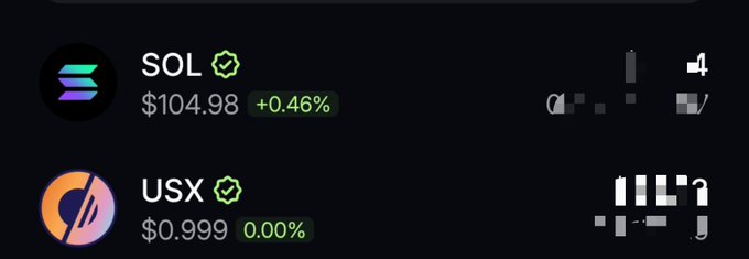 A cryptocurrency price display showing SOL at $104.98 (+0.46%) and USX at $0.999 (0.00%) on a dark background.