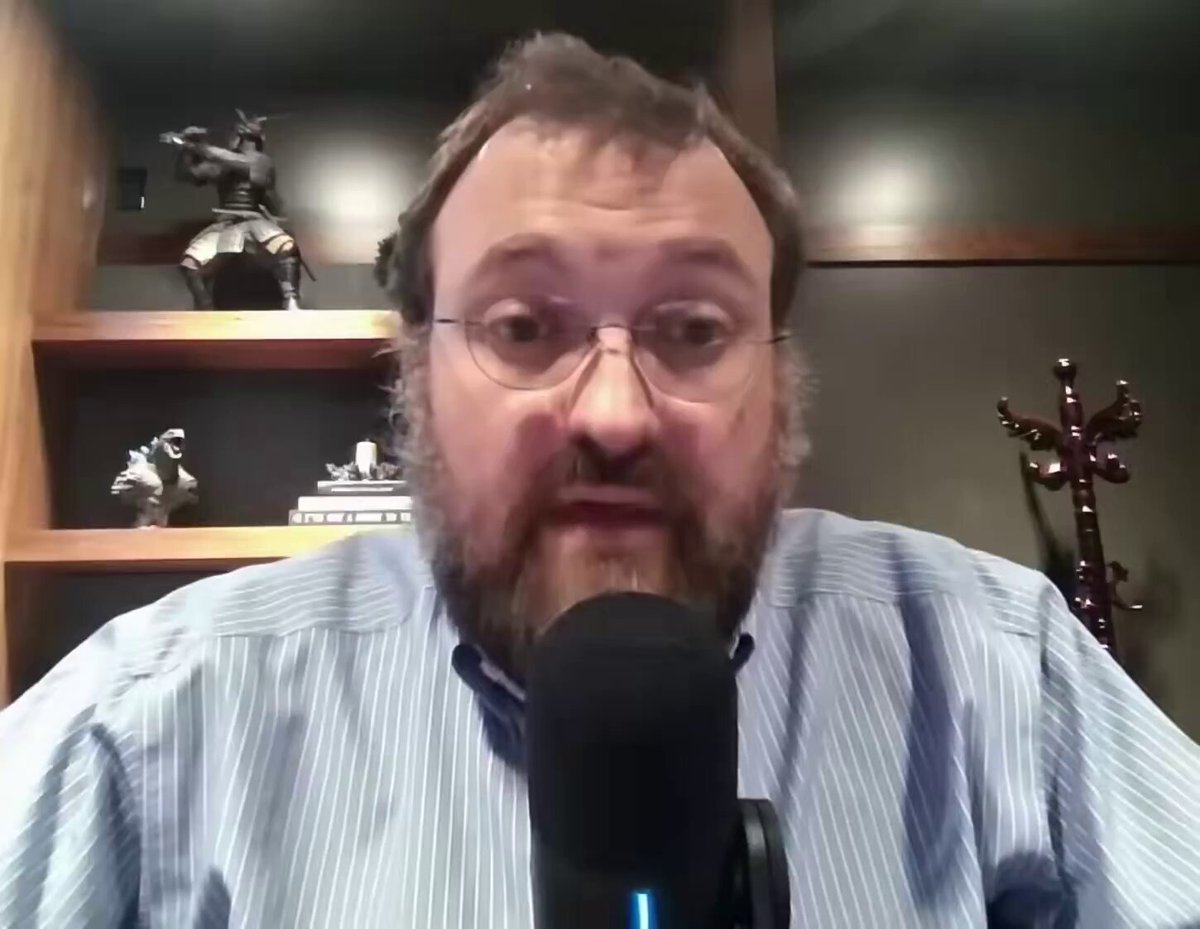 The image shows a man wearing glasses, sitting behind a microphone with his hands on his knees while talking into it. The man appears to be engaged in a conversation or presentation, possibly discussing nuclear option legislation. In the background, there are several bookshelves filled with various items such as figurines and other objects, suggesting that this might be an office or workspace setting.