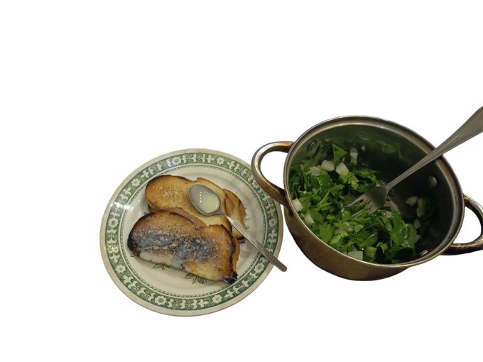 Top-down photo of a meal: a patterned plate with toasted bread (one topped with a spread) and a small spoon, alongside a brass pot of chopped greens/vegetables with a spoon.