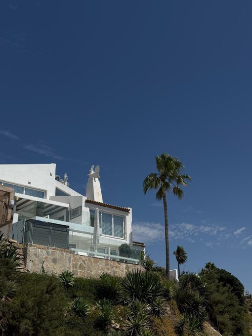 A modern white villa perched on a sunny hillside with a tall palm tree against a deep blue sky evokes a fresh, optimistic start to the week—mirroring the upbeat "Good morning Web3" greeting welcoming readers back.