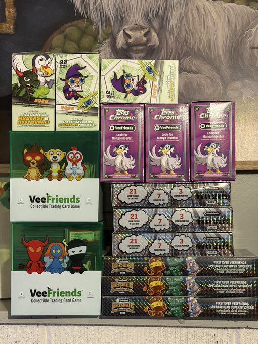 A display of VeeFriends collectible trading card merchandise, including Topps Chrome packs, exclusive booster boxes, and first-edition packs.