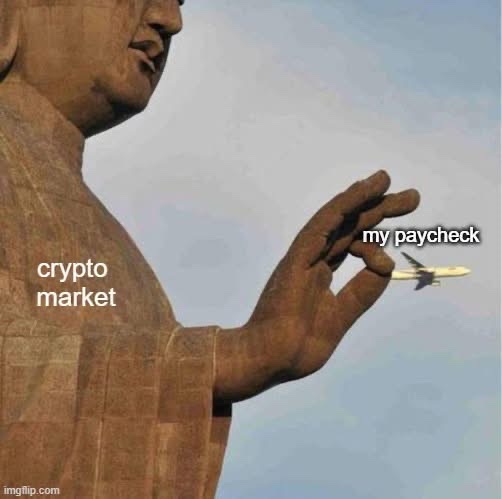 A meme shows a large Buddha-like statue casually flicking away a small airplane, with text labeling the statue as the "crypto market" and the airplane as "my paycheck." The image humorously suggests that the crypto market effortlessly dismisses ordinary income.