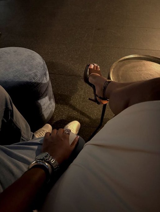 Two people relax on a couch, with one showing off white sneakers and a watch while the other's legs are crossed in heels near a side table, reflecting the cozy, grateful nighttime vibe of the post.
