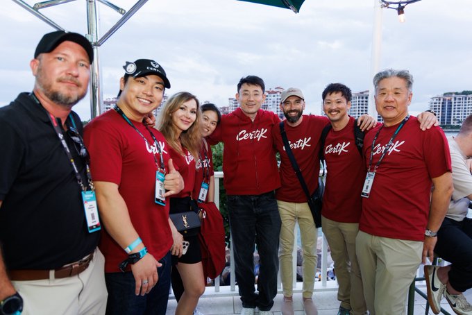 A group of people wearing red 'CertiK' t-shirts pose together for a photo, likely at a company event.