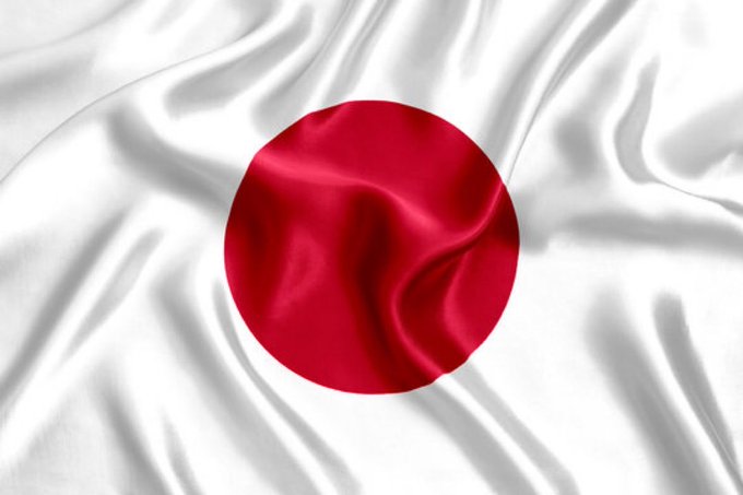The flag of Japan is depicted with a silky, wavy fabric texture, featuring a red circle on a white background.
