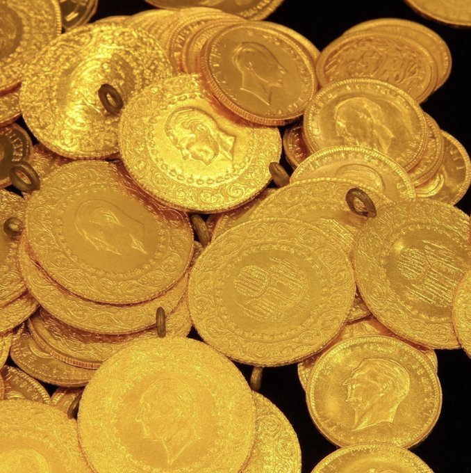 A pile of gold coins featuring portraits of men, resembling Turkish or Middle Eastern currency, set against a dark background.