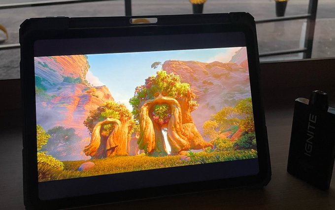 The image shows a tablet computer screen displaying an animated scene with two trees, one of which has a person sitting under them. A bottle of Snapple juice is also present next to the tablet. The text "Gn God bless to $Sui holders" appears in the image, possibly indicating that someone purchased the tablet and left it on display for others to see.