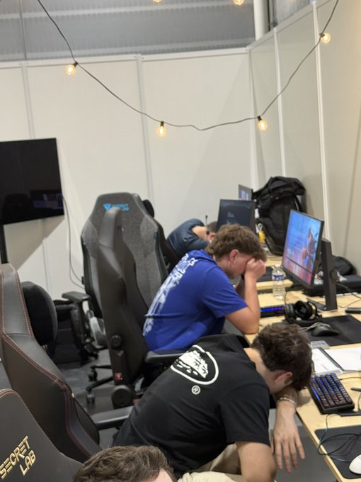 Participants in EWC, possibly at a gaming event, appear to be resting their heads on their desks after intense training, reinforcing the idea that "training starts in the mind."