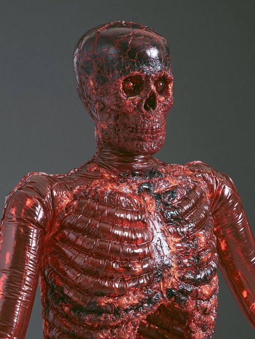 A 3D rendered skeletal figure with a glossy, red and black lava-like texture covering its skull and ribcage.
