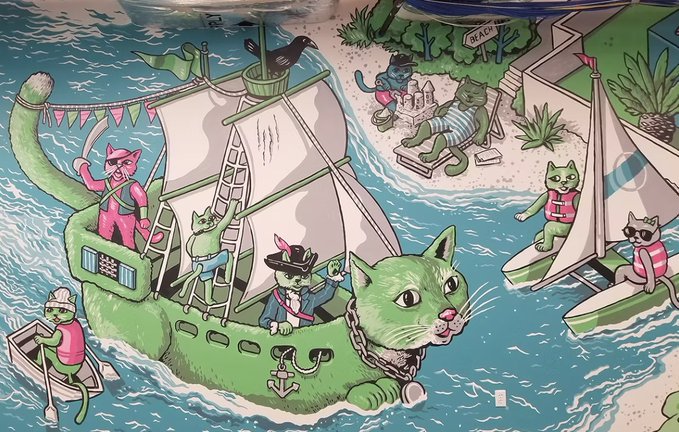 A whimsical mural depicts cats and a large green cat-shaped pirate ship sailing turquoise waters, with a small "BEACH" sign on the island and an anchor emblem featuring the letter "R" on the ship's hull—fitting imagery for the 57-foot Robinhood mural by Nigel Sussman that prominently features Rocket as the cat-figurehead.