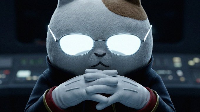 A plush cat character with glowing white glasses and white gloves sits with clasped hands in a contemplative, scheming pose against a dark control panel background. The image humorously reinforces the post's message of stubborn diamond-handing $KET, depicting the trader as calmly plotting their moon mission with unshakeable conviction.