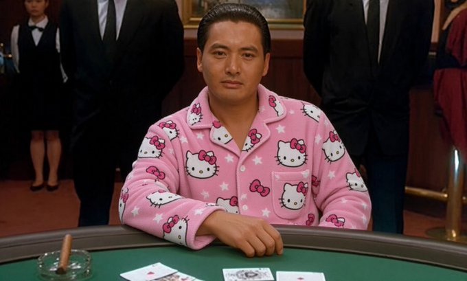 A man in a pink Hello Kitty pajama shirt sits confidently at a green-card blackjack table, smiling at the camera. The whimsical head-to-toe kitten print contrasts with the high-stakes casino setting, humorously echoing the post's playful "Going all in on kitty" message tied to a cat-themed financial push.