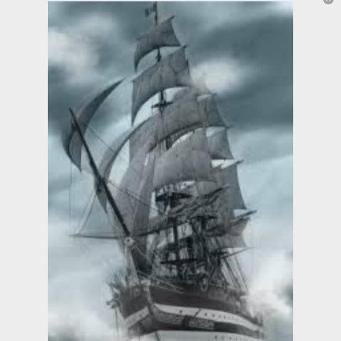 A grayscale image of a tall sailing ship with multiple billowing sails against a dramatic cloudy sky.