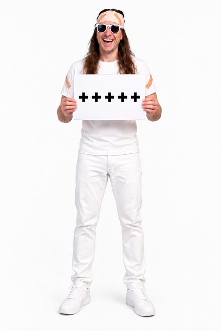 A cheerful man with long hair, wearing all white clothing, white sunglasses, and a white bandana, holding up a sign displaying four plus signs '++++'.