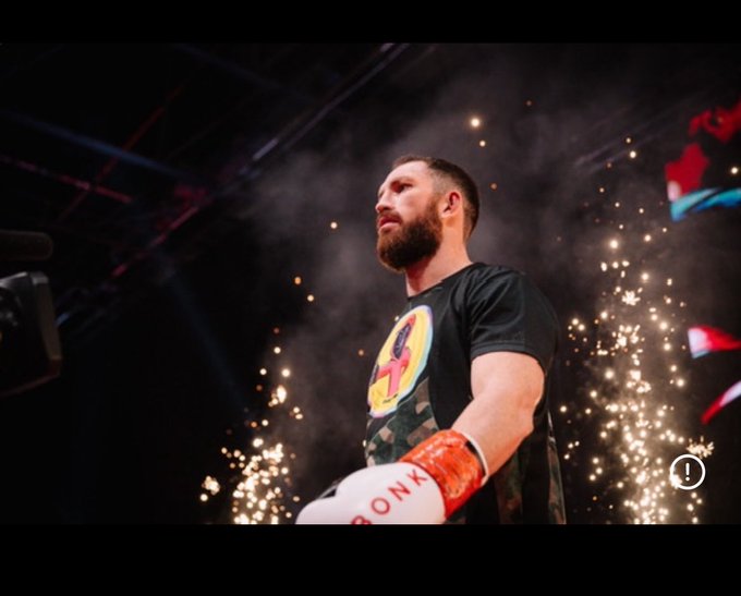 A bearded boxer with "BRONK" visible on his glove stands amid dramatic pyrotechnics and smoke under arena lights, with the accompanying post urging viewers to "drop your sol wallets" within 43 minutes—using the fighter's intense entrance as hype for an urgent crypto call-to-action.