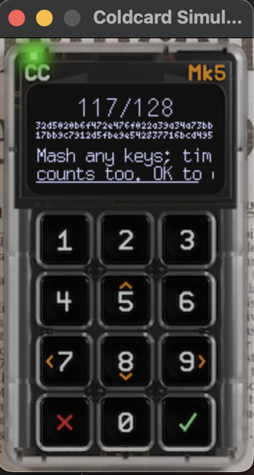 A digital simulator interface for a 'Coldcard Mk5' hardware wallet displaying '117/128' on its screen along with a partial hexadecimal string and the instruction 'Mash any keys; tim counts too. OK to'.