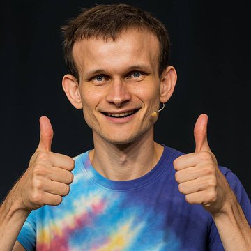 A smiling man with short brown hair, wearing a tie-dye shirt, gives an enthusiastic double thumbs-up against a dark background. His excited, approving expression perfectly captures the positive reception of Vitalik Buterin's announcement about Ethereum's ambitious "Lean Ethereum" upgrade.