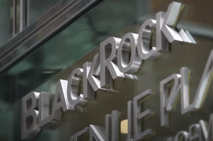 The image shows a large window displaying the name "BlackRock" written in silver letters. The text appears blurry or smudged, which might make it difficult to read at first glance. However, upon closer inspection, one can see that the letters are clearly visible and legible. This could be due to the use of a high-quality printing technique or the fact that the window is clean and well-maintained. The blurry appearance may have been caused by an attempt to create a more artistic or unique look for the window display, but it ultimately fails to achieve its intended effect.