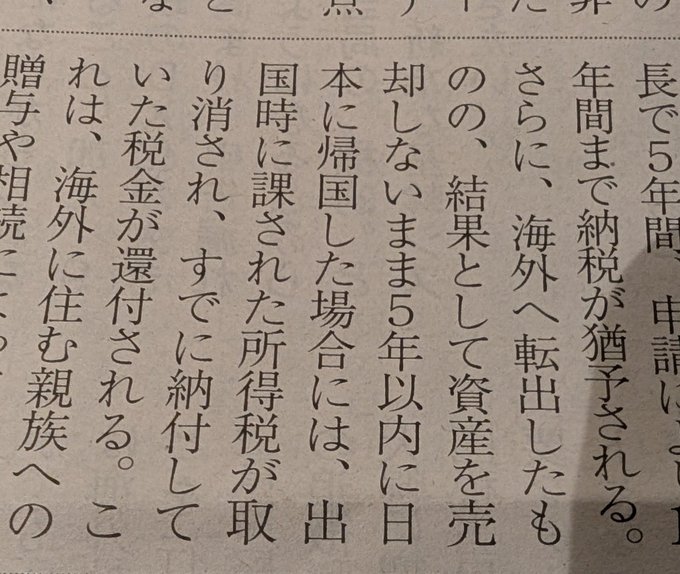 A close-up of a Japanese newspaper article discussing exit tax regulations, specifically detailing the five-year retention period and tax obligations for assets when moving abroad. The visible text explains that assets purchased and held for over five years before returning to Japan are not subject to exit tax, directly relating to the post's explanation of cryptocurrency tax exemptions after returning from tax-free jurisdictions.